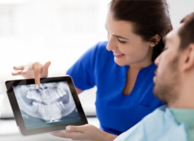 A dentist showing a male patient a digital X-ray of his mouth