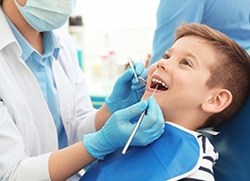 happy toddler boy opening mouth for dental hygienist