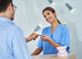 Patient paying the cost of treating dental emergencies in Acworth